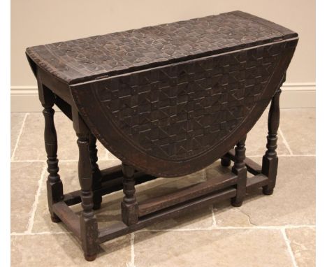 A 19th century carved oak gateleg dining table, the chequer carved oval top upon baluster, bobbin and block supports united b