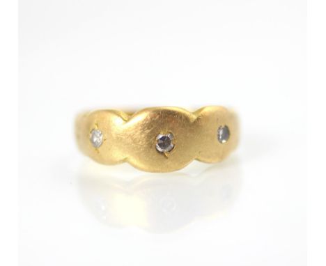 A yellow metal and diamond bespoke ring, of organic triple rounded form set with three round cut diamonds, stamped ‘18ct’ rin