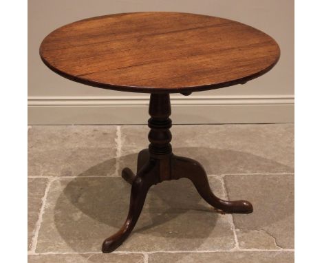 A George III oak tripod table, the circular tilt top upon a turned and tapering column extending to three cabriole down swept