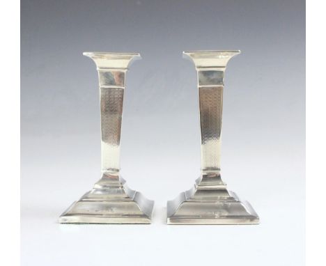 A pair of George V silver candlesticks, Henry Matthews, Birmingham 1911, the square shaped terminal above engine turned taper