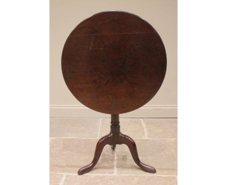 A George III mahogany tripod table, the circular top upon a bird cage mechanism and a ring turned gun barrel column extending
