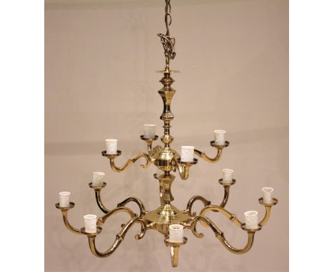 A gilt brass chandelier, 20th century, formed with a central column and two graduated tiers of 'S' shaped arms, four over eig