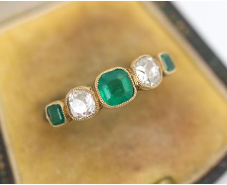 An early 20th century untested emerald and diamond ring, the three untested graduated emeralds with old cut diamonds in-betwe