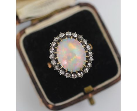 A 19th century precious opal and diamond cluster ring, the oval cabochon opal claw set within a surround of twenty old cut di