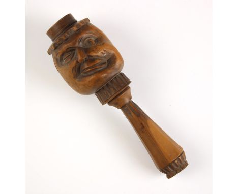 A treen novelty nut cracker, late 19th/early 20th century, the front carved with a face, geometric design to handle, 14.5cm h