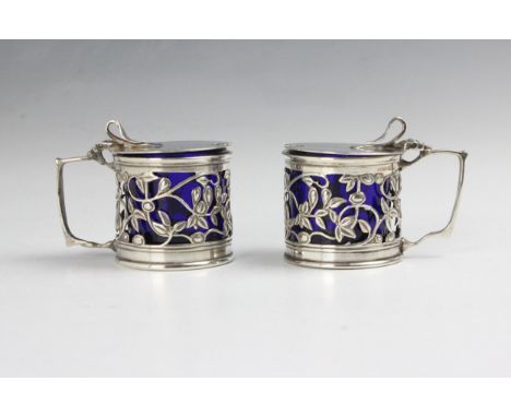 A pair of Edwardian silver wet mustards, William Hutton &amp; Sons Ltd, Birmingham 1903, of cylindrical form with openwork fl