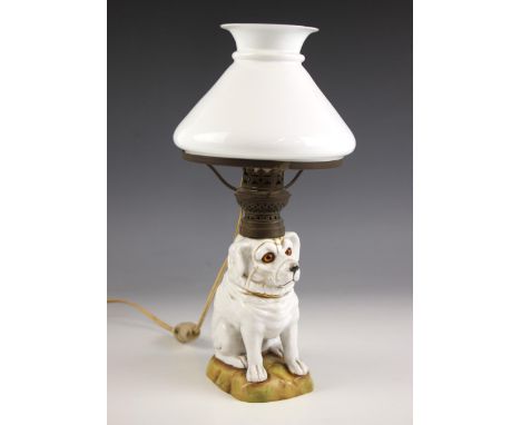 A table lamp, late 19th century/early 20th century, the base modelled as a porcelain dog, with glass eyes, upon naturalistic 