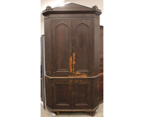 A 19th century scumbled pine freestanding corner cupboard, the architectural cornice over a pair of arcaded panelled doors, o