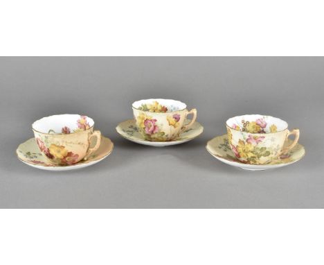 A pair of Royal Worcester blush ivory porcelain cabinet cups and saucers, with painted floral decoration with green printed f