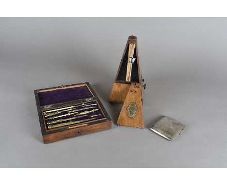 A George V silver cigarette case, a walnut cased metronome and a cased writing instrument box 