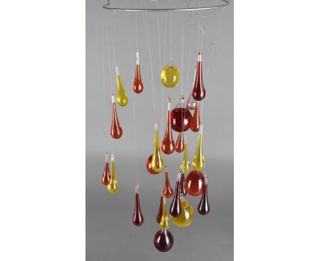 A Robert Niederer glass wall light fitting, the spiral wire fitting supporting tear shaped glass with coloured liquid 