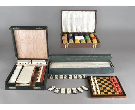 A early 20th Century travelling games set, comprising a chess board with pieces and counters, playing cards etc, together wit