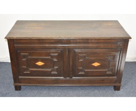 A late 18th Century oak inlaid coffer, the hinged top above an architectural frieze inlaid with light oak lozenges, on oak su