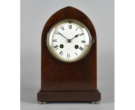 An Edwardian eight day mantle clock, white enamel face with Roman numerals, within an arched mahogany case chequered strung, 