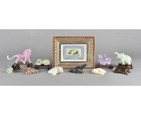 A collection of Chinese hardstone carved animals, including a rose quartz lion, a jade sleeping dog, an amethyst mythical bea