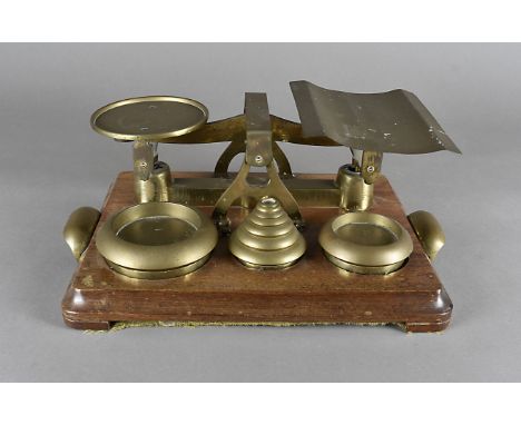 A set of W & T Avery brass balance scales, on mahogany plinth support, 41 cm x 28 cm 
