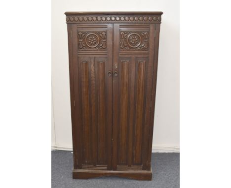 A 1930's oak linen Eddershaws of Swansea hall cupboard, pair of panel drawers, a fitted shelf and hanging interior, 76 cm wid