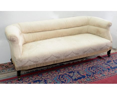 A VICTORIAN UPHOLSTERED SOFA ON SQUARE TAPERED LEGS WITH BRASS CASTORS