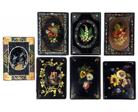 SEVEN VICTORIAN PAPIER MACHE BLOTTING BOOKS, PAINTED WITH FLOWERS, A CASTLE OR DECORATED IN INLAID MOTHER OF PEARL WITH BIRDS