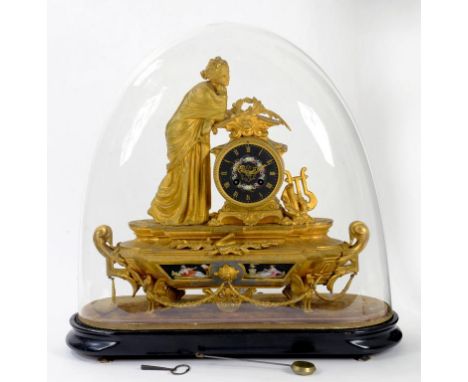 A FRENCH GILTMETAL MANTLE CLOCK WITH FLORAL PAINTED BLACK GROUND PORCELAIN DIAL ON VELVET LINED AND EBONISED WOOD PLINTH BENE