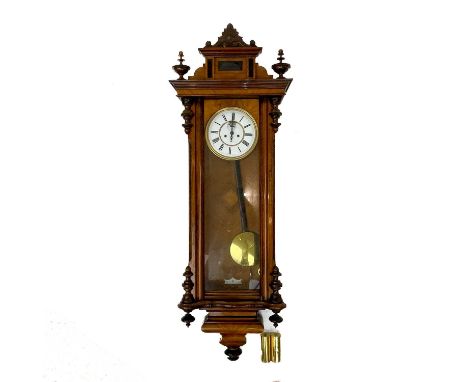 A walnut cased Vienna regulator type wall clock. With circular white enamel dial and twin brass weights, height 136cm.