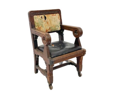 An oak Gothic revival armchair, in the Pugin taste. Circa 1850, with paterae carved top rail, moulded scroll arms carved with
