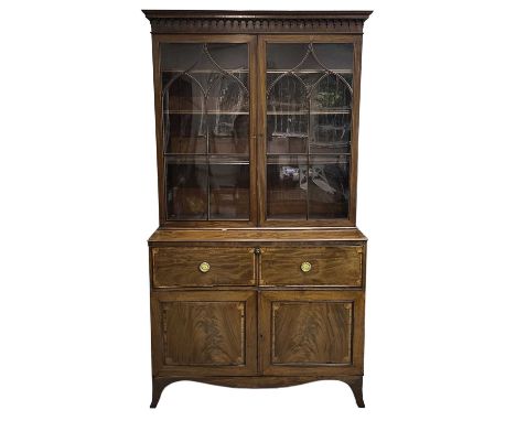 A George III mahogany and satinwood banded secretaire bookcase. With an arcaded frieze, above two arched glazed doors, the lo