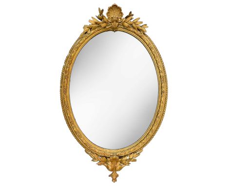 A late 19th century gilt framed oval mirror Decorated with scalloped shell pediment and floral motifs, surrounded by pearl be