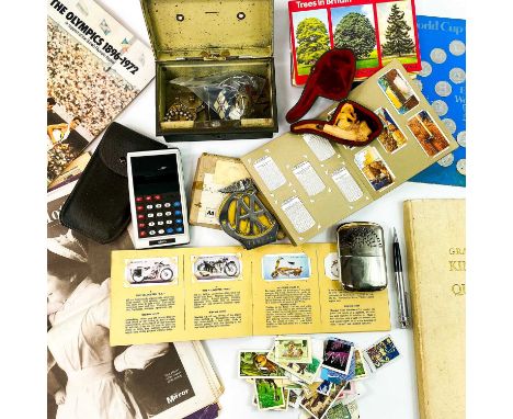 An assortment of miscellanea. Including a Royal Devon and Exeter enamel nursing badge, an AA car badge coins postcards, cigar