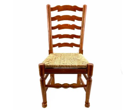 An Arts and Crafts style ash and elm ladder back child's chair. With drop-in rush seat on a turned underframe, height 75cm, w
