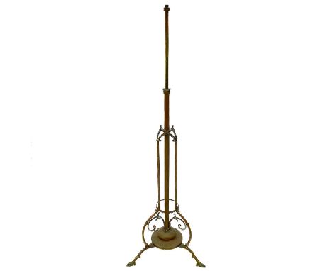 An Aesthetic movement brass telescopic oil lamp base. Circa 1880, the column with Gothic arch mounts and raised on pointed pa