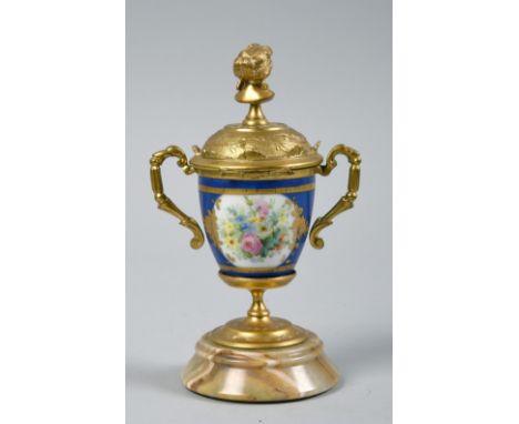 A late 19c French ormolu and porcelain two handled decorative urn on onyx stand, the urn with hinged dome cover with female b
