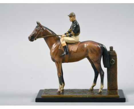 An early 20c horse and jockey table lighter painted, the jockey in racing colours, 17in w, 7in h.