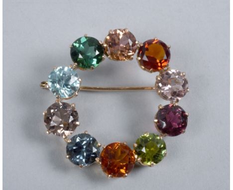 A gold multi coloured stone set brooch of circular form, 1.4in diam.