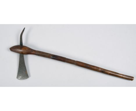 A 19c African battle axe, the head of the shaft carved with roundels, the axe head with simple incised decoration and with sp