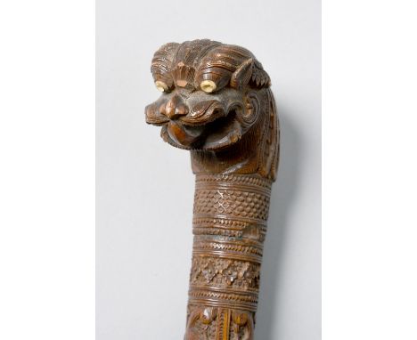 A late 19c Oriental carved hardwood walking stick of tapering form, panel carved with animals in jungle settings and with a l