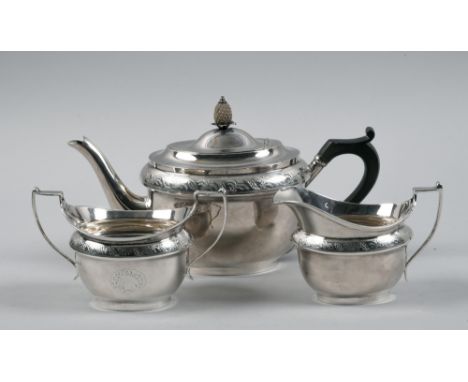 A late Georgian style three piece silver tea service comprising teapot, sucrier and cream jug, the teapot with a hinged dome 