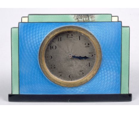 An early 20c silver and enamel bedside clock with silvered circular face, the enamel in shades of blue and green and having w
