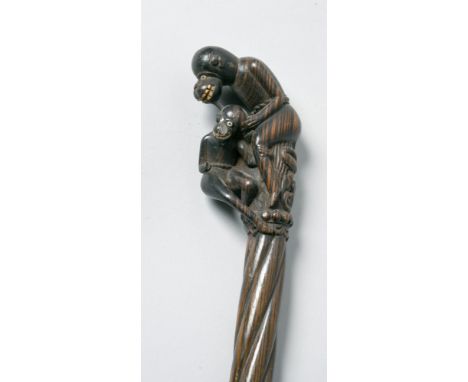 A 19c Oriental hardwood walking stick with a twist carved handle carved as two monkeys, 34.5in l.