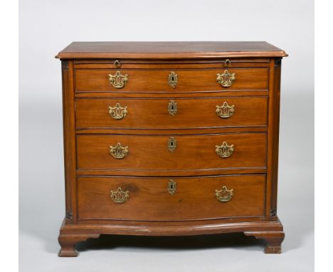 A George III mahogany serpentine chest  of four long graduated drawers with a slide, within column pilasters and supported on