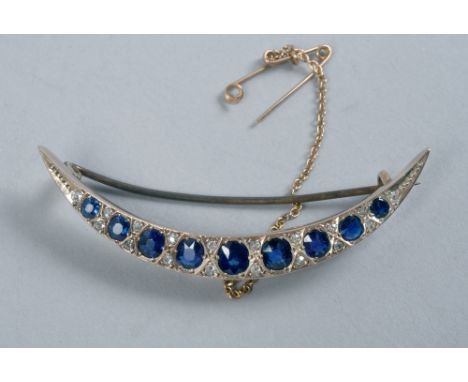 A yellow gold diamond and sapphire set crescent brooch, 2.25in w.