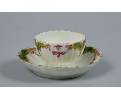 A Worcester fluted teabowl and saucer decorated in the Sevres style with a border of puce garlands and green and gilt diaper 