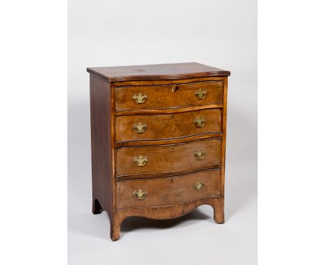 An early 19c figured walnut veneered serpentine small chest of four long drawers, the top with reeded edge and having shaped 