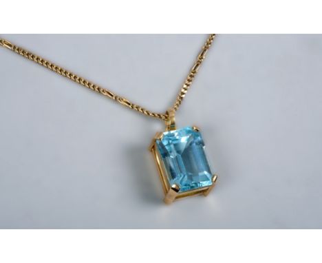 A yellow gold cut aquamarine set pendant with gold chain.