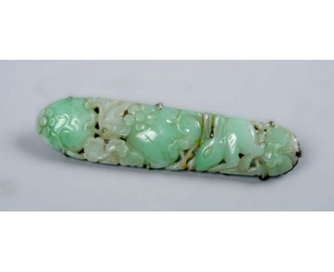 An early 20c Oriental jade bar brooch carved with a hare, fruit and flowers, 3in w.