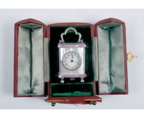 An early 20c miniature carriage type clock with a watch movement in a brown leather gull wing case, the clock 2.5in h with ha