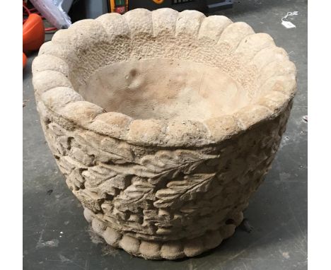 A composite stone planter decorated with oak leaves 