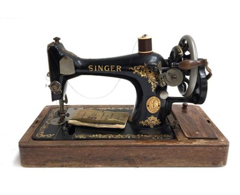 A vintage Singer sewing machine, number Y1704941, together with accessories and manual, in oak carry case, with key 