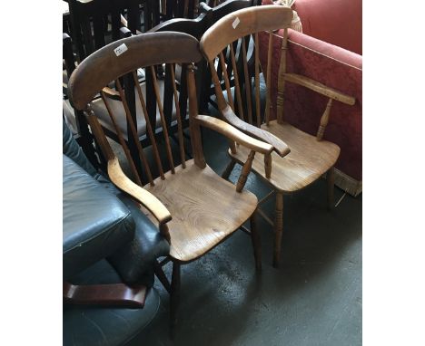 Two elm and beech kitchen elbow chairs, stick backs over shaped seats, raised on ring turned legs and H stretchers 