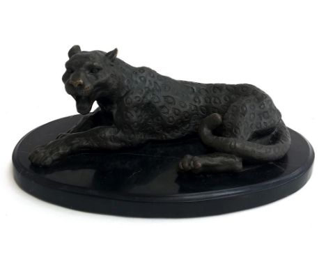 A bronze reclining leopard, with Asian stamp, on oval base, 28cm long 